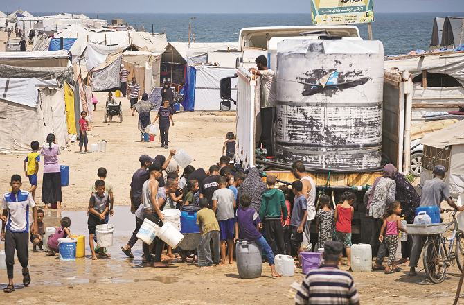 People queue for water during the scorching heat in Gaza. Photo: AP/PTI