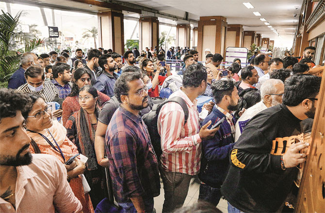 Passengers queue up to get flight information at a counter at Ahmedabad airport. (PTI)