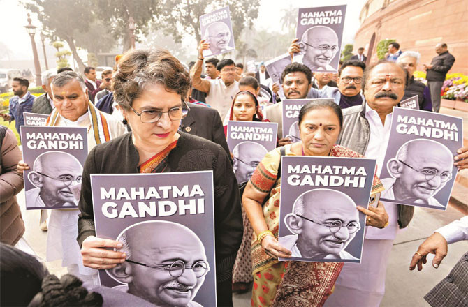 Opposition MPs protesting with pictures of Gandhiji.