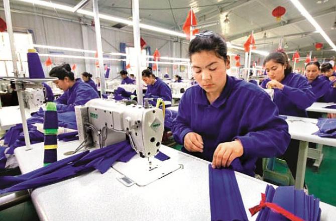 Uyghur women can be seen sewing clothes at an ongoing textile factory in Xinjiang. Photo: INN