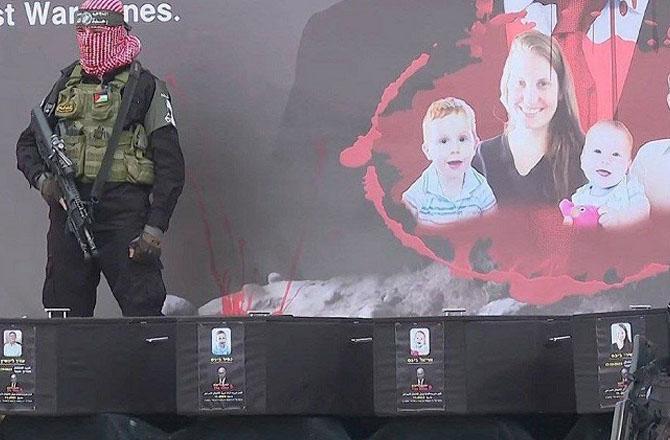 A Hamas fighter guards the coffins of Israeli hostages killed in Israeli attacks. Photo: X