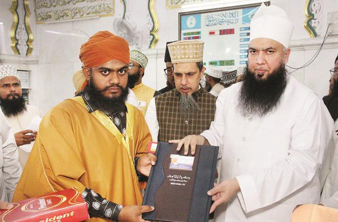 Maulana Syed Moinuddin Ashraf, his brother Syed Hussain Ashraf presenting the certificate of memorization and recitation to graduating student Hafiz Junaid Alam. Photo: INN.