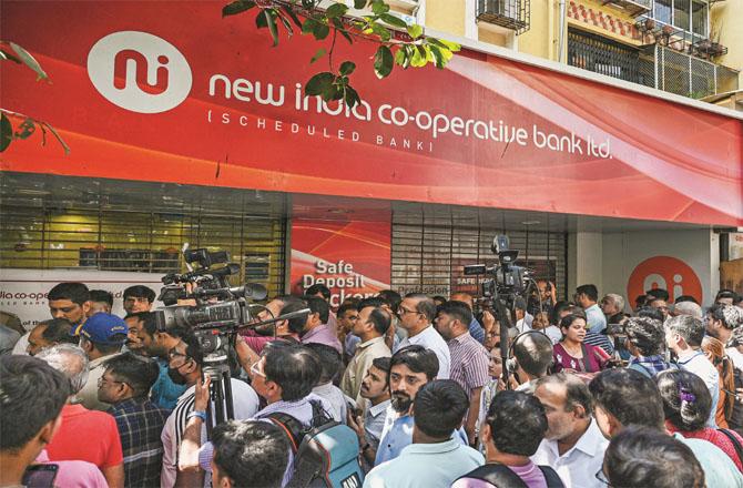 Account holders are seen gathering outside a branch of the New India Cooperative Bank. (Photo: PTI)