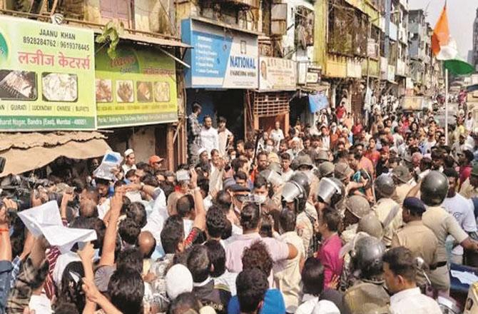 Police officers try to control an angry crowd in Bharat Nagar.
