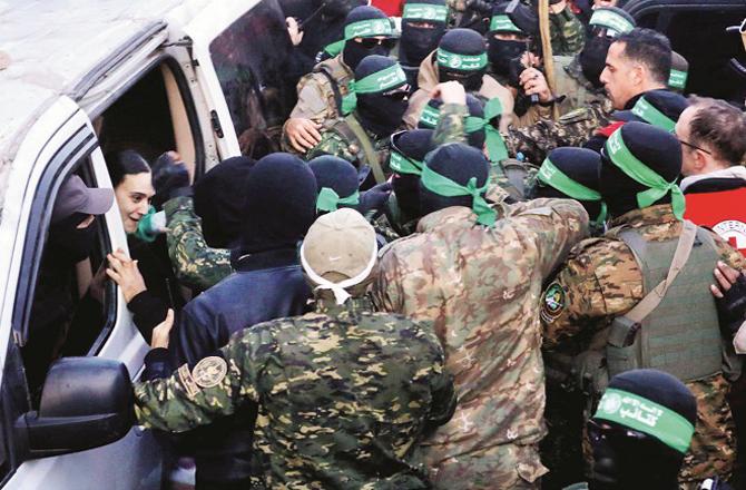 Hamas fighters hand over an Israeli woman to the Red Cross. Photo: PTI.