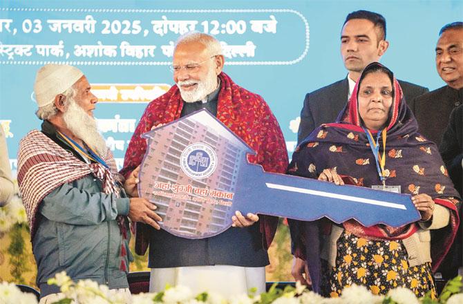 Prime Minister Modi handing over the keys to the poor who got houses. (PTI)