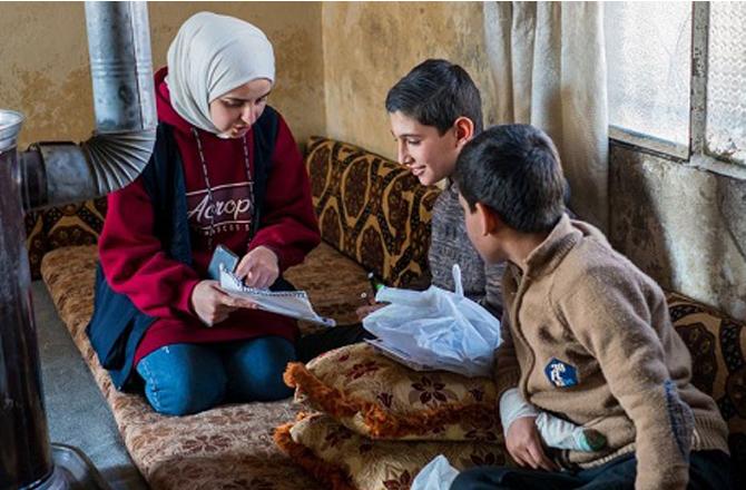 A UNICEF official explains to children about her organization`s work. Photo: INN.