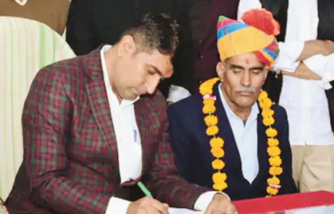 Shyam Sunder (son) signing the retirement order of Jugaram (father). Photo: INN