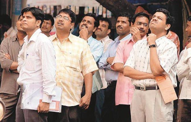 Investors standing outside the BSE kept staring at the screen hoping for an improvement, but the market continued to roll. Photo: INN