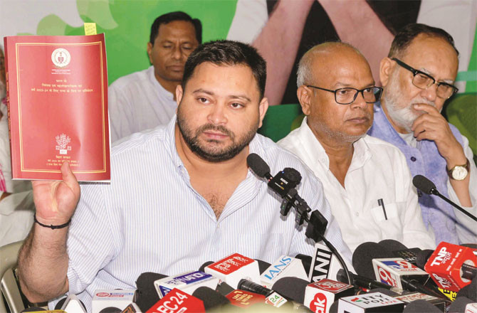 Tejashwi Yadav showing the CAG report at a press conference held at his residence in Patna.