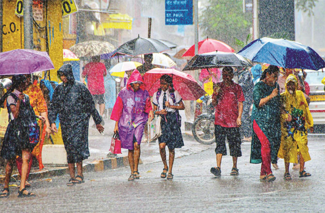 People walk through the streets during heavy rain in Mumbai.