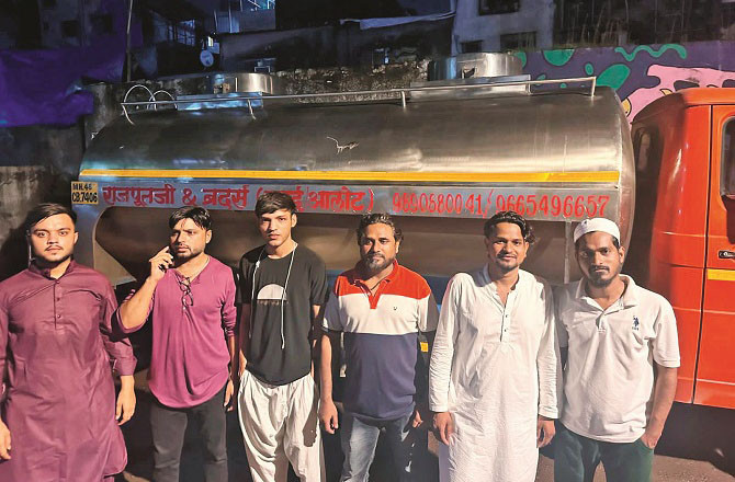 Locals stand next to a milk tanker. Photo: INN.