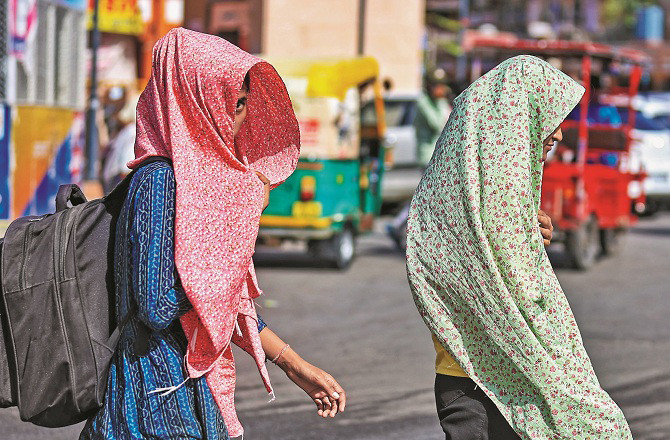 Women cover their heads and faces to protect themselves from the scorching sun in Jaipur. Photo: INN