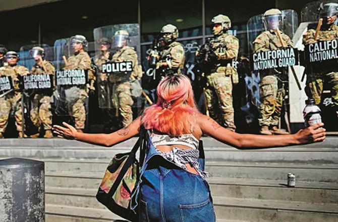 A woman protests in front of soldiers in Los Angeles against the deployment of the National Guard. Photo: INN