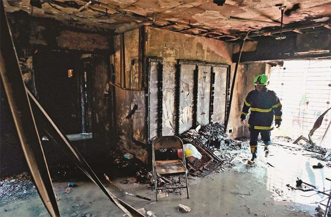 A firefighter inspects a house damaged in a fire. Photo: INN