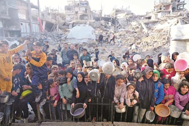 Palestinian civilians wait for aid at an aid center in Beit Lahia, Gaza Strip. Photo: AP/PTI