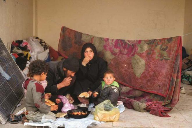 A Palestinian family in Gaza is seen breaking their fast with bread and tomato sauce. Photo: INN