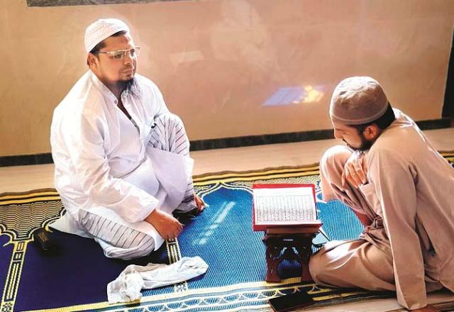 Hafiz Muhammad Rahmatullah Muhammad Nabi Hassan Sheikh (left) giving alms before Taraweeh. Photo: INN