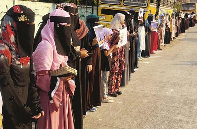 GIO workers protest by forming a human chain on the road in front of Urdu Ghar. Photo: INN