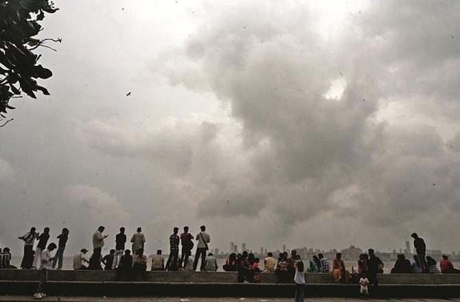 People enjoy the pleasant weather on Marine Drive while dark clouds are visible in the sky. Photo: Atul Kamble