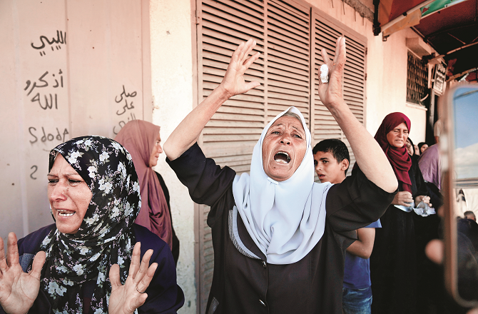 Israeli attacks continue despite peace plan. Women digging up their graves. Photo: AP/PTI