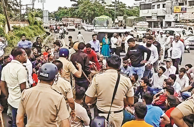 Muslim youth sit on the street and protest as police try to pick them up. Photo: INN