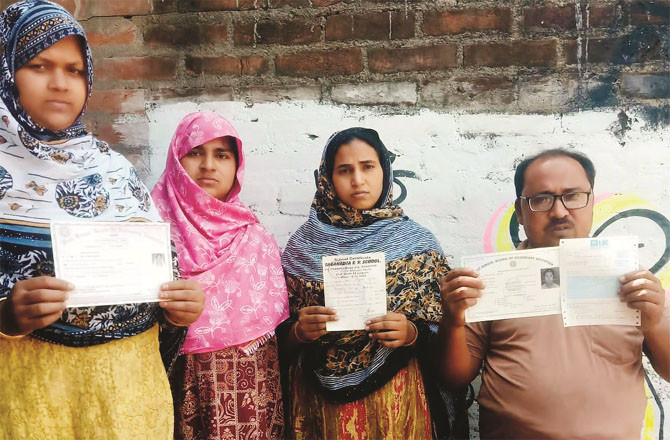 Muhammad Aneeq-ul-Haq showing documents outside his house in Murshidabad. 8 out of 9 names in his family have been removed from the SIR.