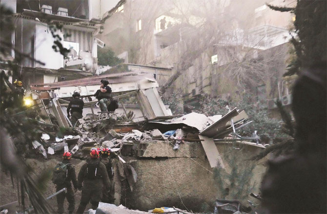 Israeli rescue workers are seen busy after an Iranian attack on central Israel. (AP/PTI)