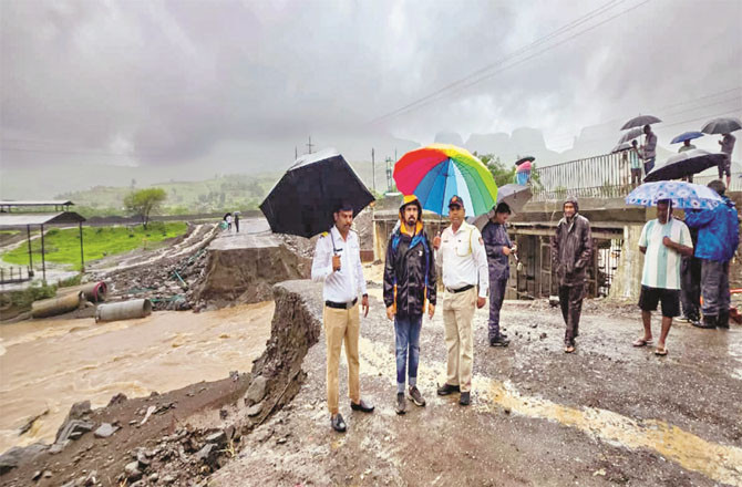 Officials inspect a flooded road in Trimbakeshwar taluka of Nashik. (PTI)