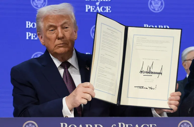 Donald Trump showing a file after signing the Peace Board. Photo: INN