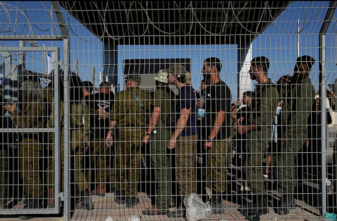 Israeli soldiers gather at the gate of the Sde Teiman detention center. Photo: INN