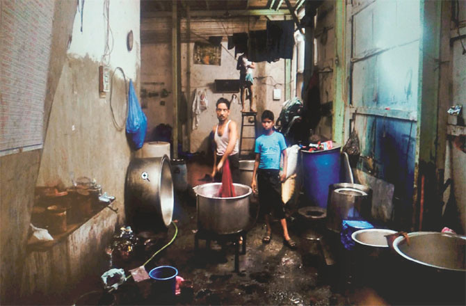 A worker is seen busy at work in a cloth dyeing factory in Dharavi.